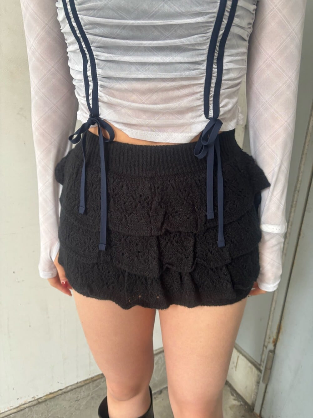 ブラック系のブーツ、ブラック系のスカート、ホワイト系のTシャツ/カットソーを着用したレディースの春コーディネートの5枚目の写真