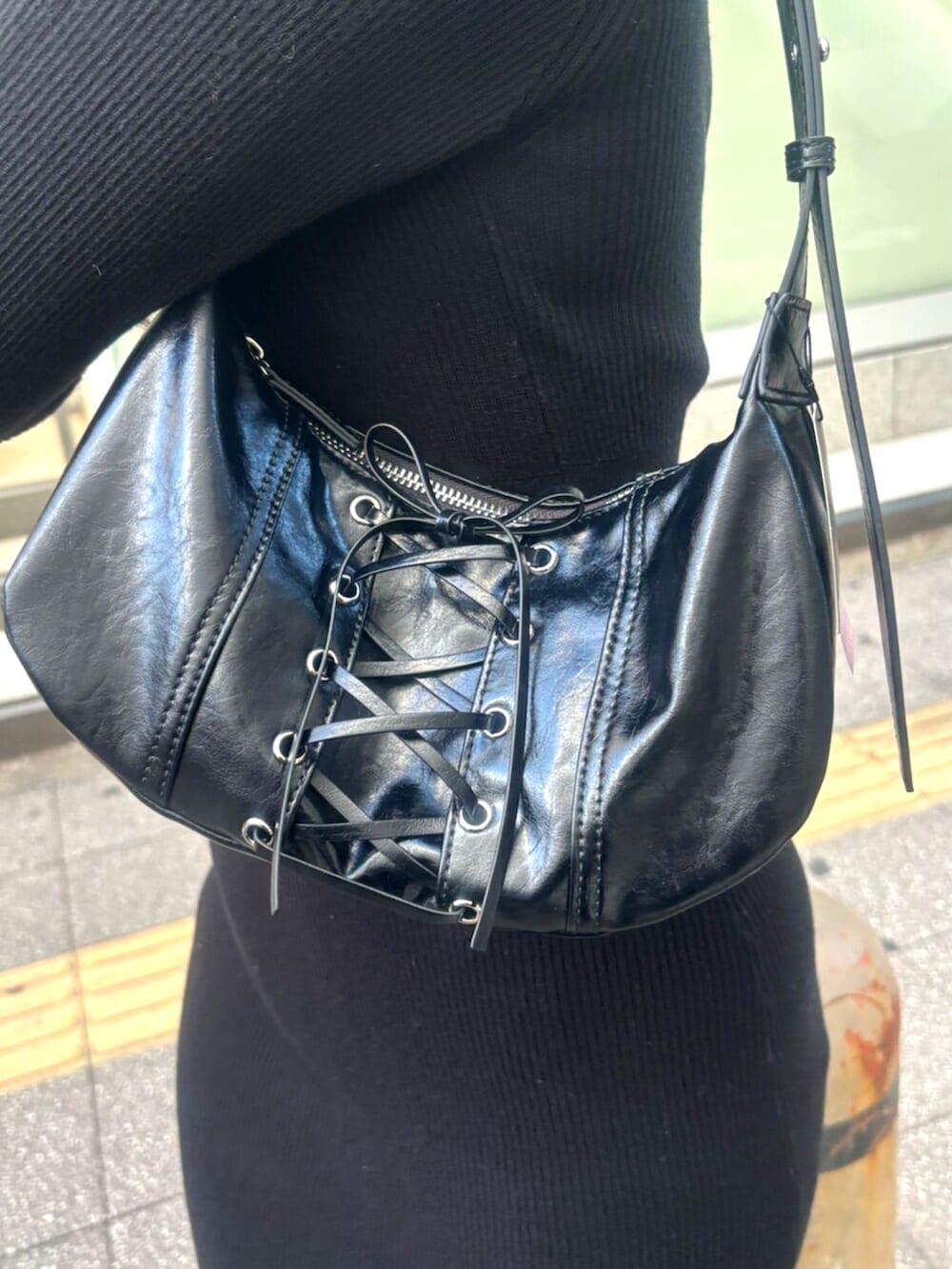 ブラック系のブーツ、ブラック系のワンピース、ブラック系のショルダーバッグを着用したレディースの冬コーディネートの7枚目の写真