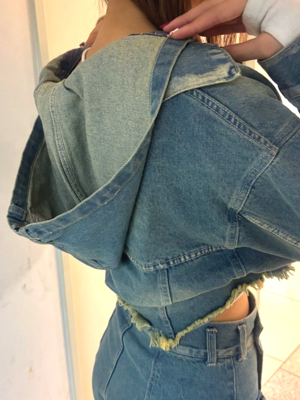 ブラック系のブーツ、ブルー系のデニムジャケット、ホワイト系のTシャツ/カットソーを着用したレディースの冬コーディネートの9枚目の写真