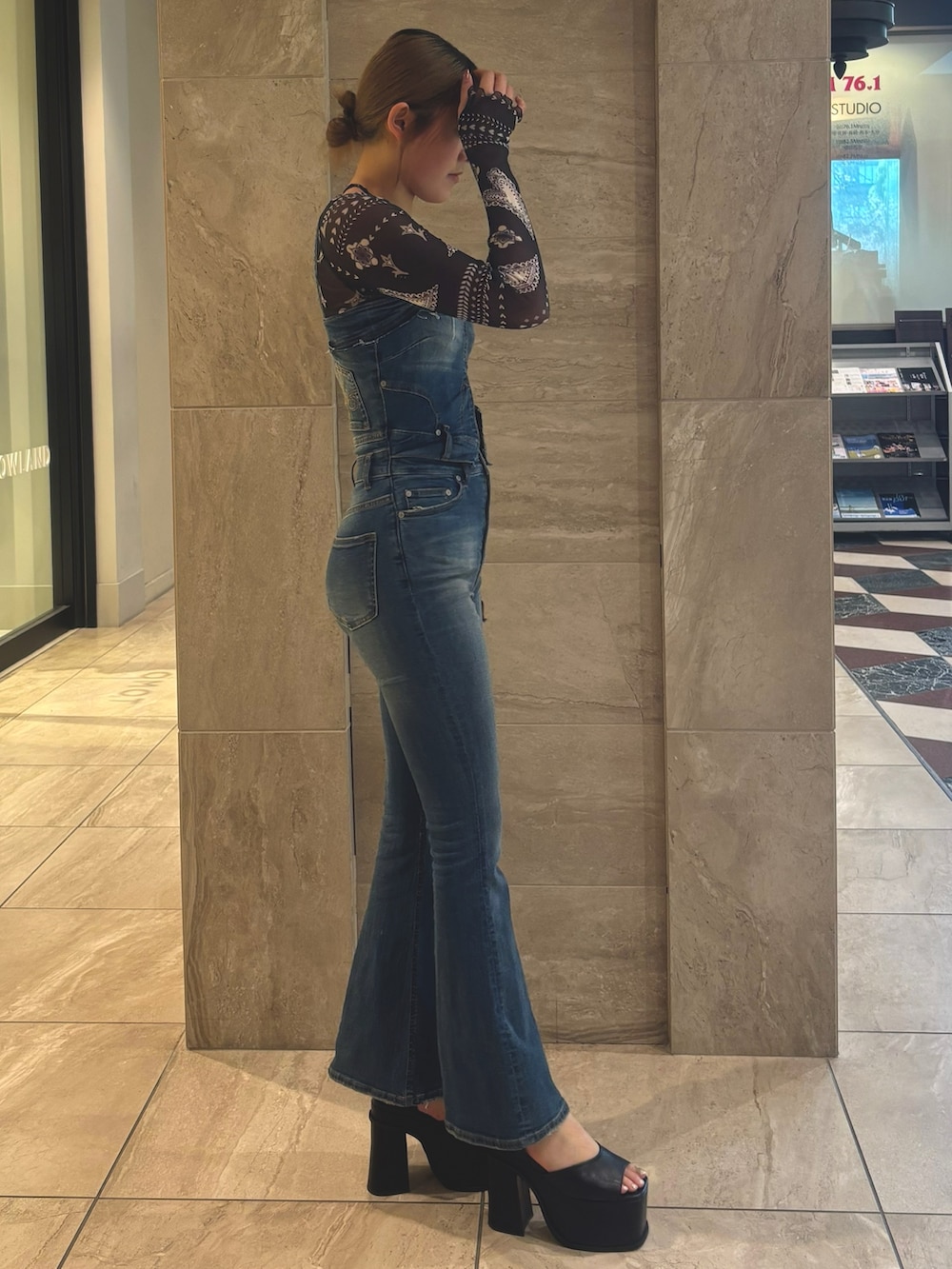 ブルー系のサロペット/オーバーオール、ブルー系のTシャツ/カットソー、ブラック系のサンダルを着用したレディースの春コーディネートの4枚目の写真