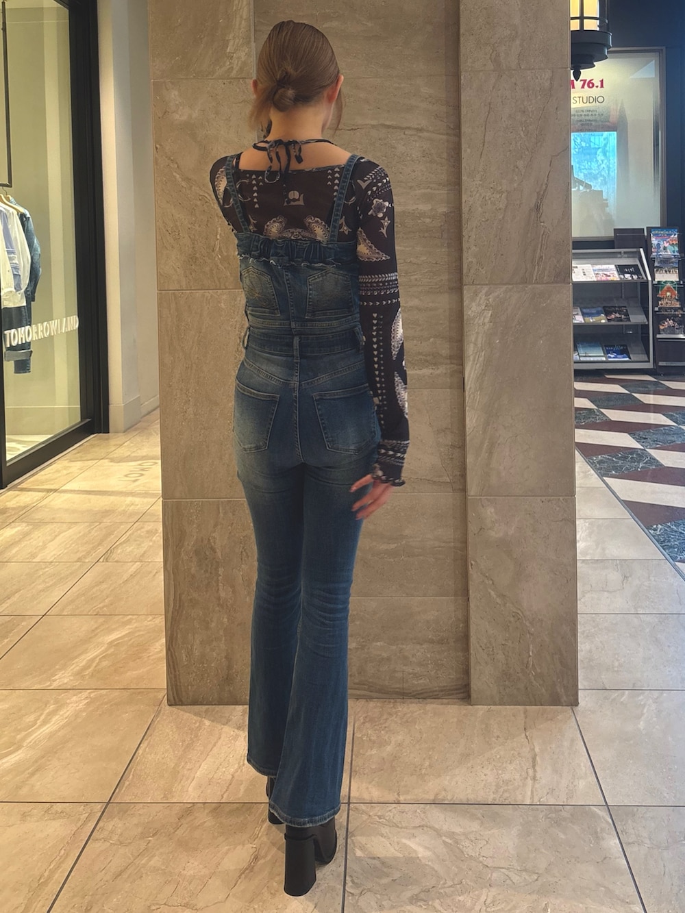 ブルー系のサロペット/オーバーオール、ブルー系のTシャツ/カットソー、ブラック系のサンダルを着用したレディースの春コーディネートの3枚目の写真