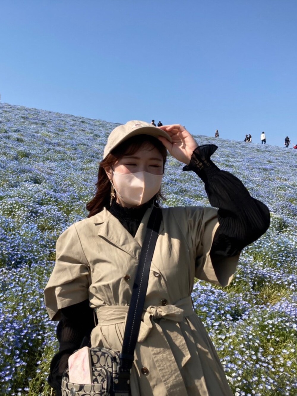 ベージュ系のワンピース、ブラック系のバッグを着用したレディースの冬コーディネートの3枚目の写真