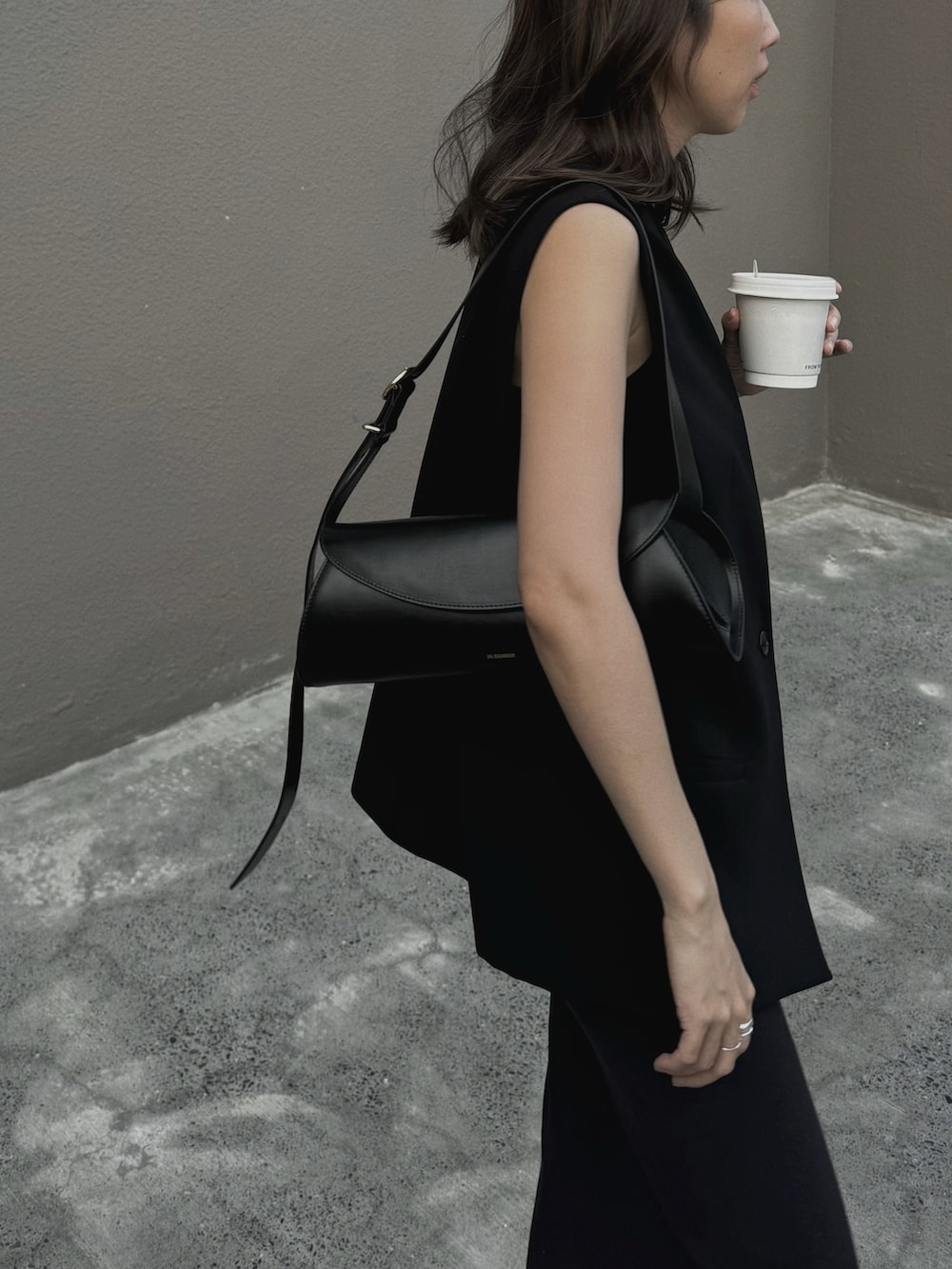 ブラック系のスーツベスト、ブラック系のハンドバッグ、ブラック系のバレエシューズを着用したレディースの春コーディネートの3枚目の写真