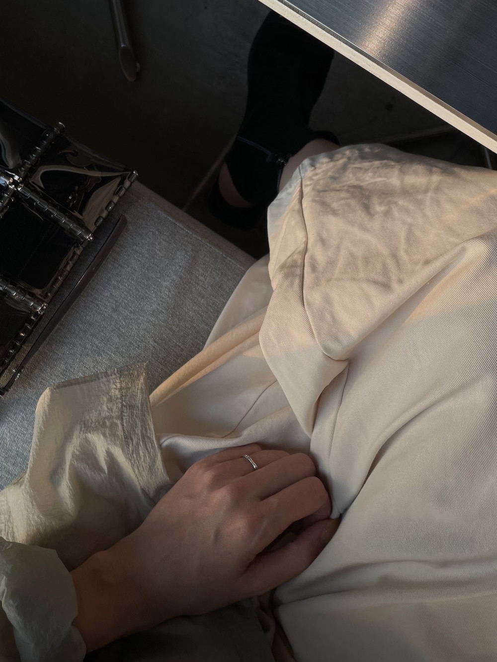 グレー系のハンドバッグ、ブラック系のブーツを着用したレディースの秋コーディネートの2枚目の写真