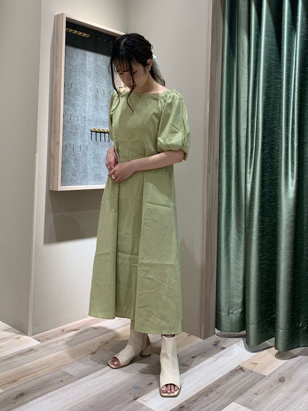 グリーン系のワンピース/ドレス、ベージュ系のトートバッグ、ホワイト系のブーツを着用したレディースの春コーディネートの3枚目の写真