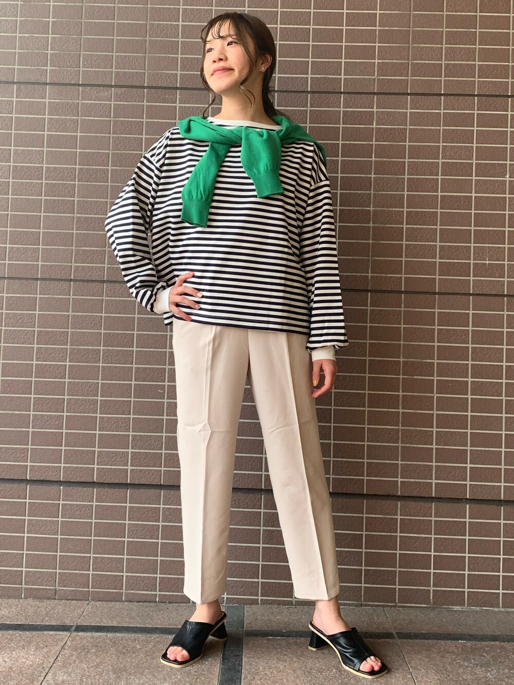 グリーン系のカーディガン/ボレロ、ブルー系のTシャツ/カットソー、ホワイト系のスラックスを着用したレディースの春コーディネートの2枚目の写真