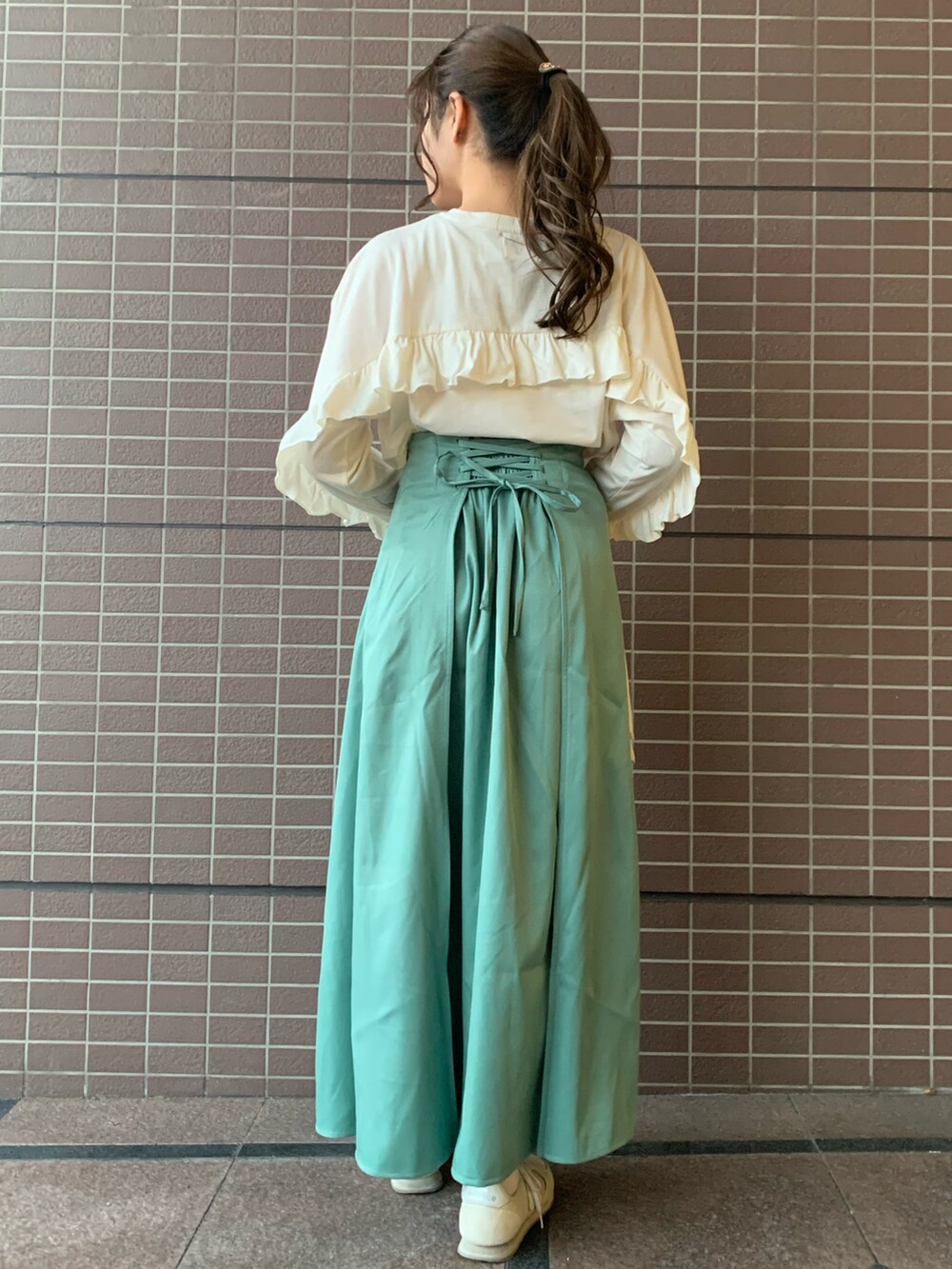 ホワイト系のショルダーバッグ、ブルー系のジャケット/アウター、グリーン系のスカートを着用したレディースの春コーディネートの2枚目の写真