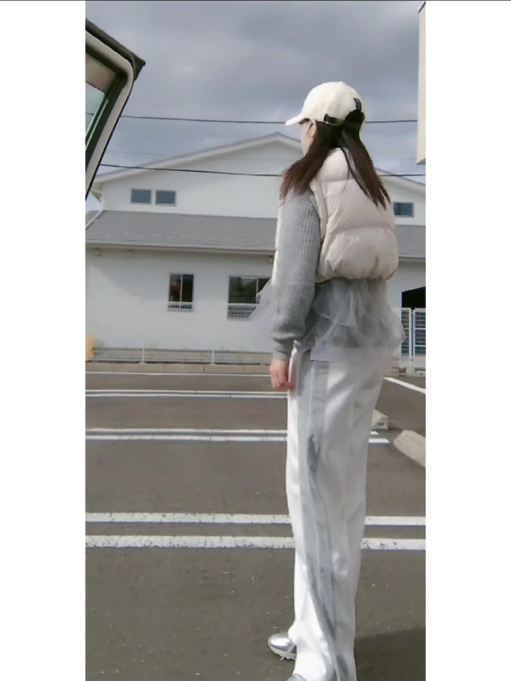 ホワイト系のダウンベスト、ホワイト系のその他パンツ、ホワイト系のキャップを着用したレディースの冬コーディネートの2枚目の写真