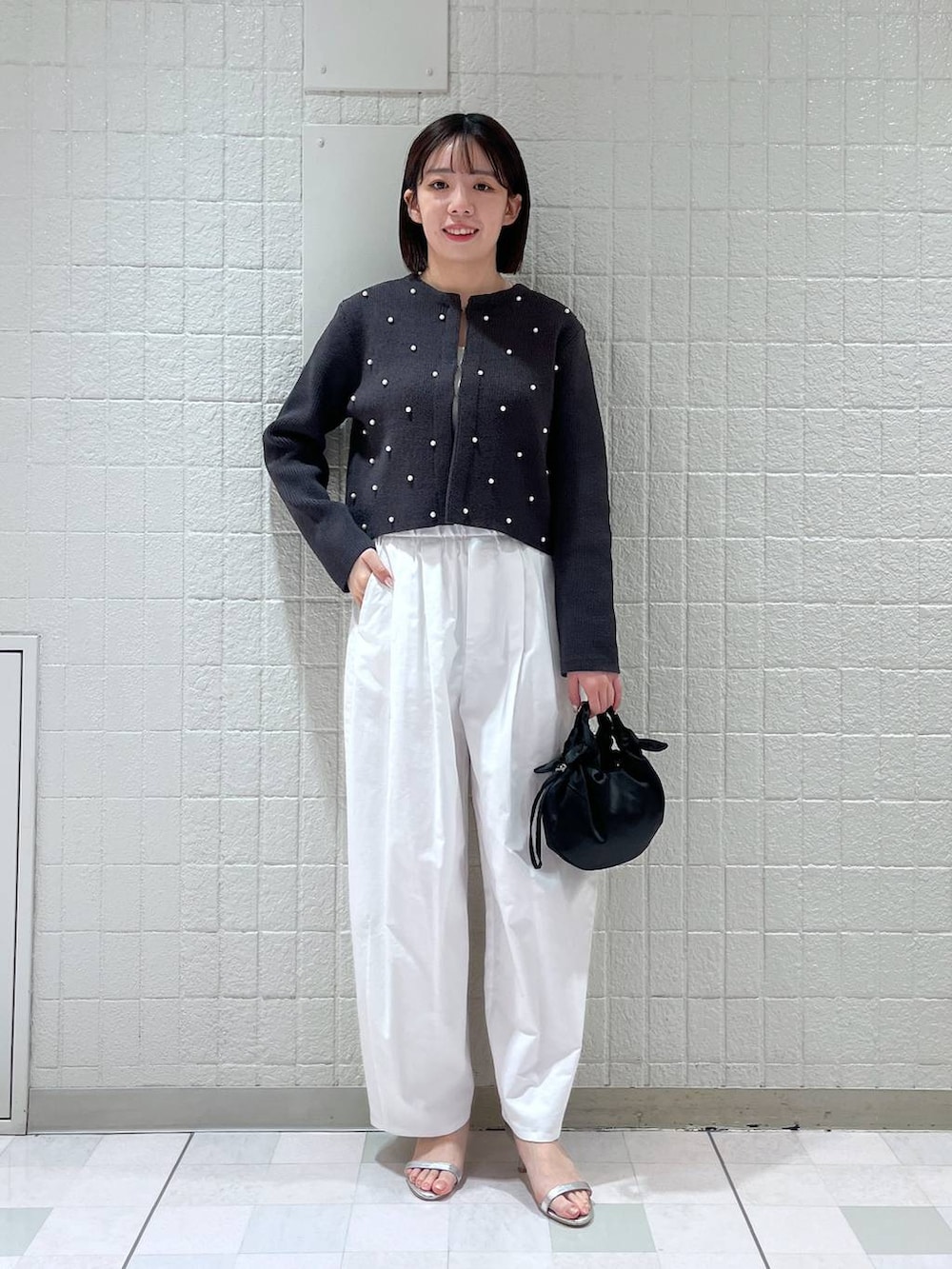 グレー系のカーディガン/ボレロ、シルバー系のサンダル、ブラック系のショルダーバッグを着用したレディースの春コーディネートの4枚目の写真