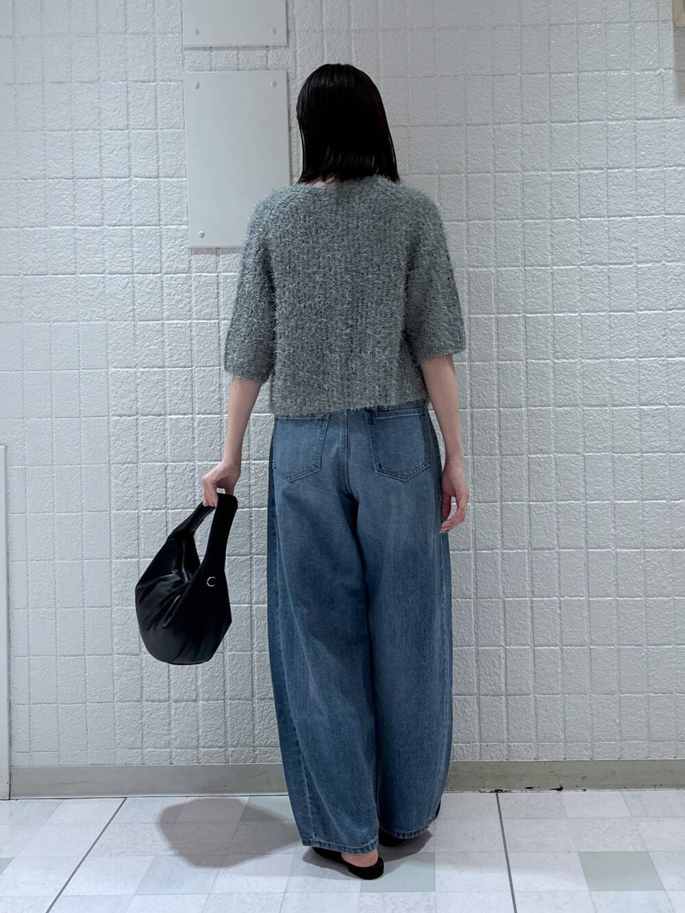 ブルー系のデニムパンツ、ブラック系のパンプス、グリーン系のカーディガン/ボレロを着用したレディースの夏コーディネートの4枚目の写真