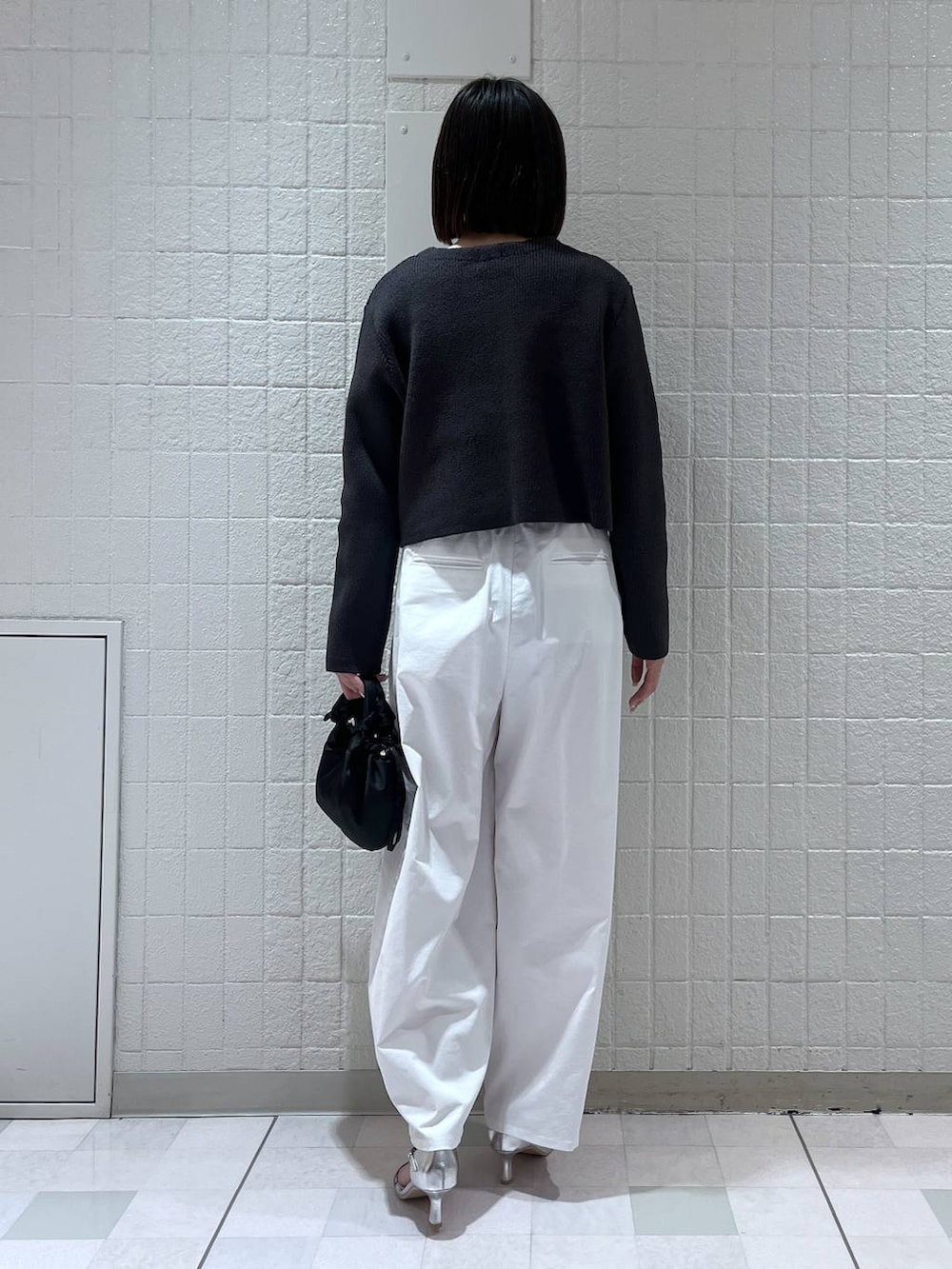 グレー系のカーディガン/ボレロ、シルバー系のサンダル、ブラック系のショルダーバッグを着用したレディースの春コーディネートの3枚目の写真