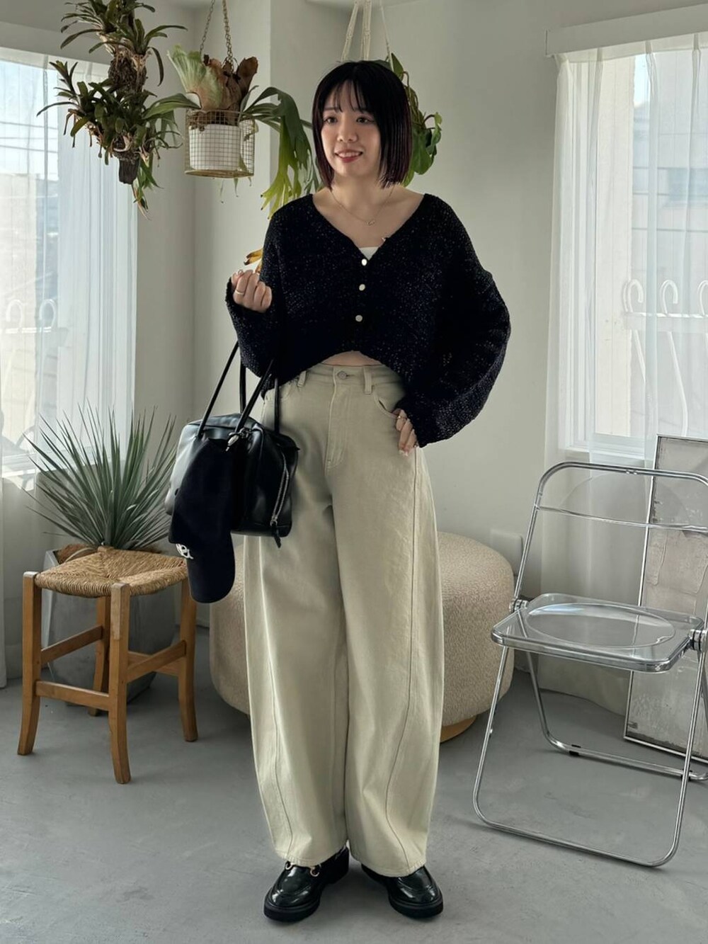 ベージュ系のデニムパンツ、ブラック系のボストンバッグ、ブラック系のローファーを着用したレディースの冬コーディネートの3枚目の写真