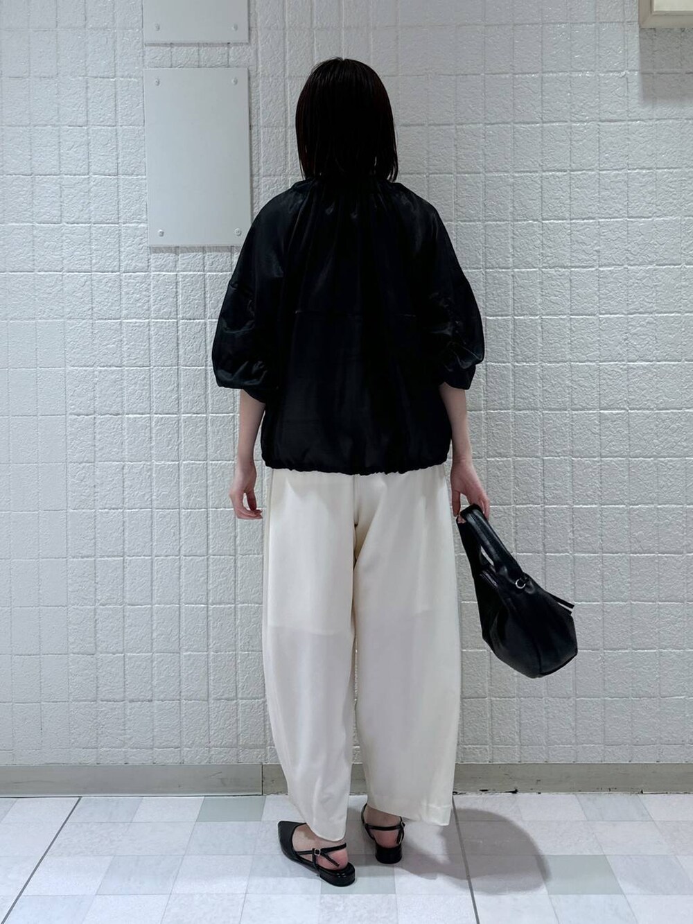 ブラック系のハンドバッグ、ブラック系のブルゾン、ブラック系のパンプスを着用したレディースの春コーディネートの3枚目の写真
