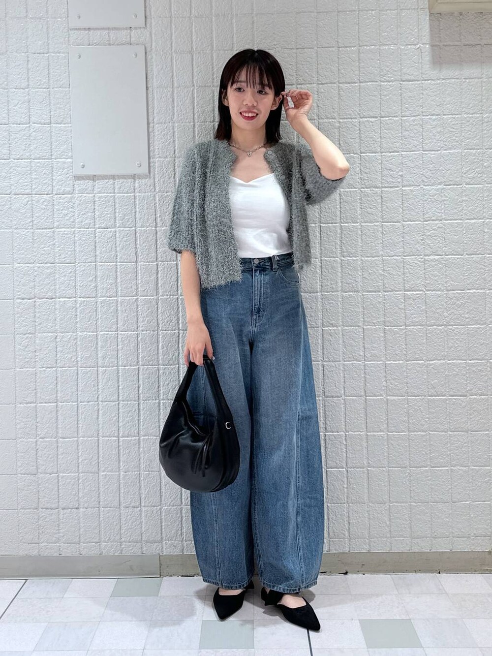 ブルー系のデニムパンツ、ブラック系のパンプス、グリーン系のカーディガン/ボレロを着用したレディースの夏コーディネートの2枚目の写真