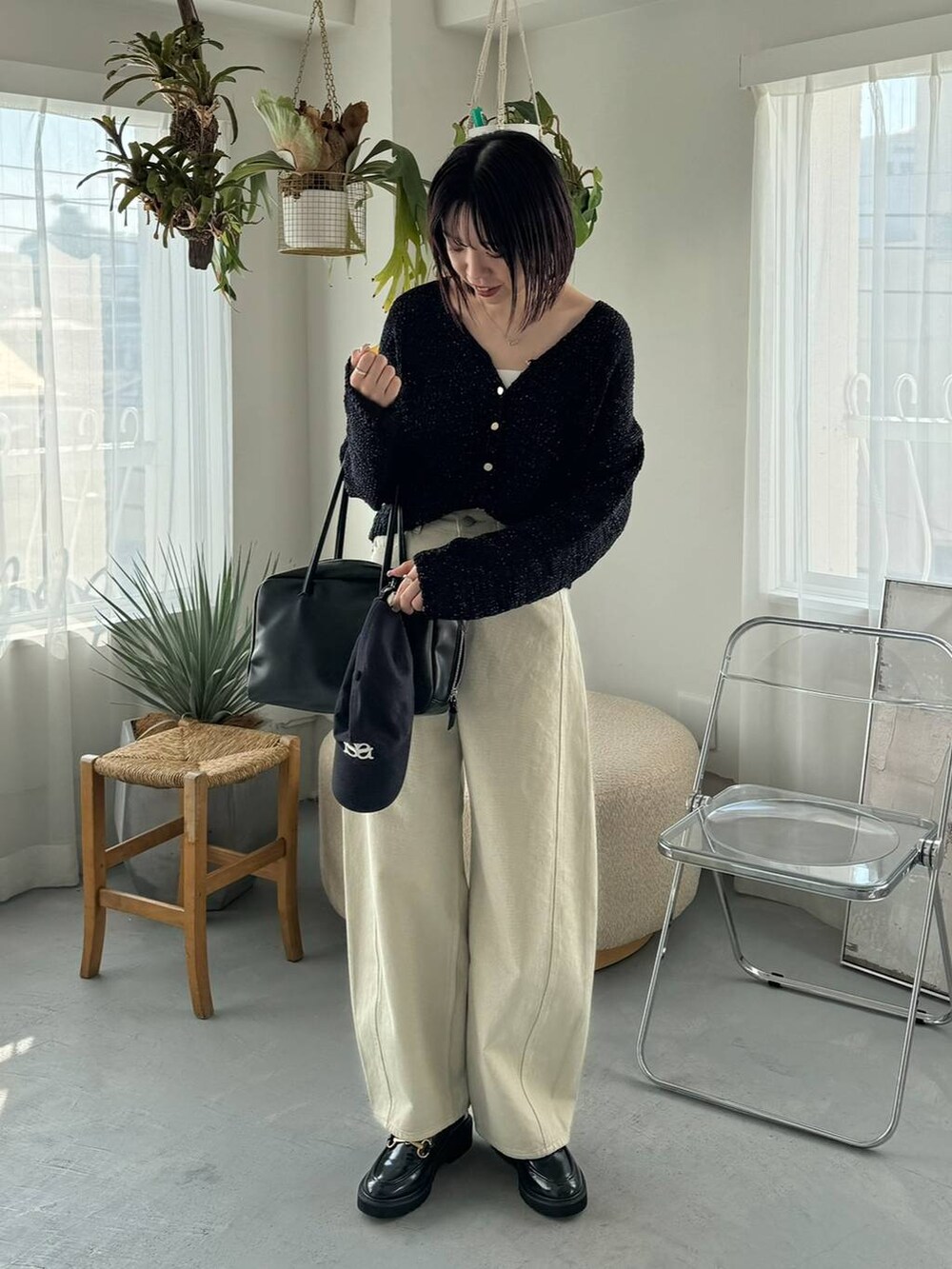 ベージュ系のデニムパンツ、ブラック系のボストンバッグ、ブラック系のローファーを着用したレディースの冬コーディネートの2枚目の写真