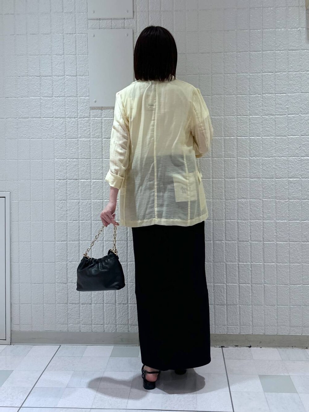 ブラック系のデニムスカート、イエロー系のテーラードジャケット、ブラック系のショルダーバッグを着用したレディースの春コーディネートの3枚目の写真