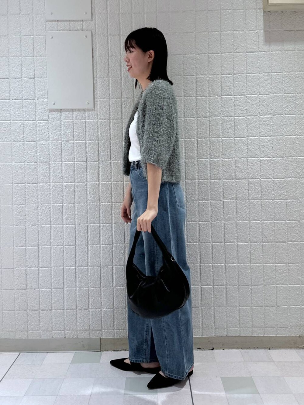 ブルー系のデニムパンツ、ブラック系のパンプス、グリーン系のカーディガン/ボレロを着用したレディースの夏コーディネートの3枚目の写真