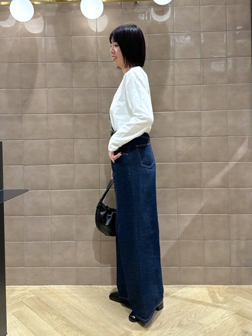 ゴールド系のネックレス、ブラック系のベルトを着用したレディースの冬コーディネートの2枚目の写真