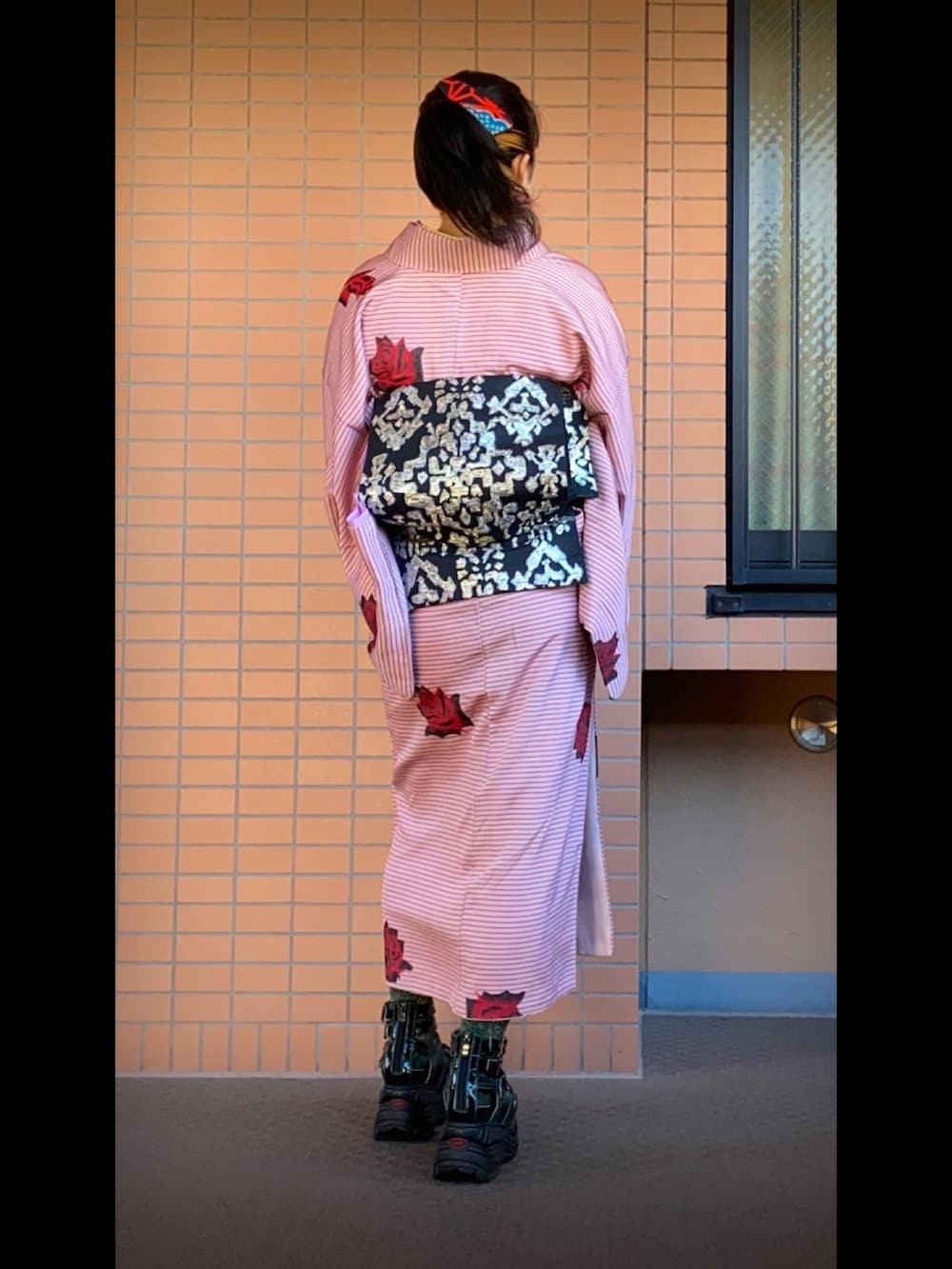 ブラック系のサンダル、ブラック系のショルダーバッグ、ピンク系のイヤリングを着用したレディースの秋コーディネートの2枚目の写真