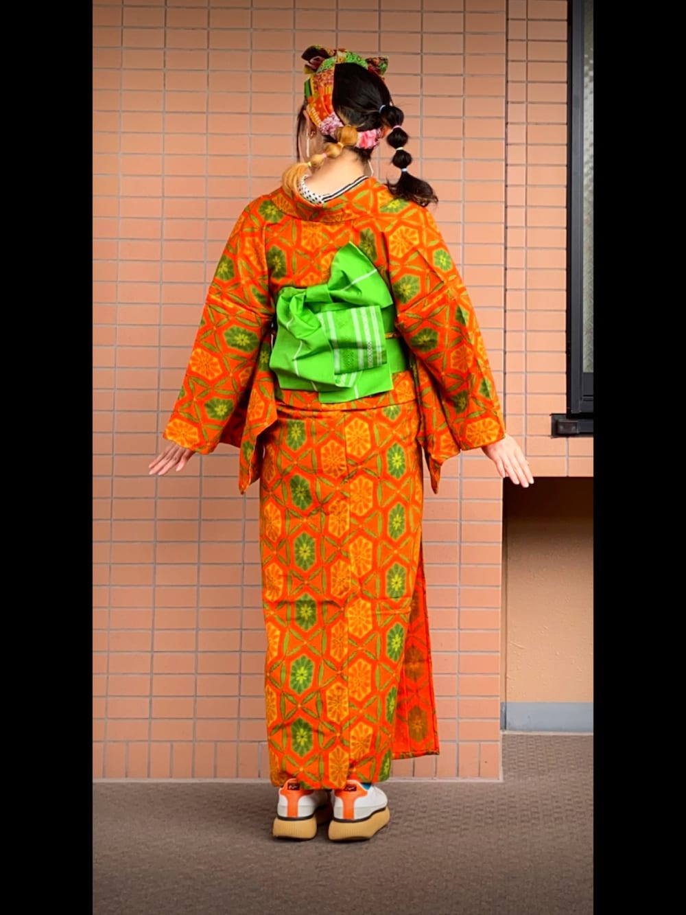 ホワイト系のスニーカー、その他のヘアバンド、オレンジ系の和装小物を着用したレディースの秋コーディネートの2枚目の写真