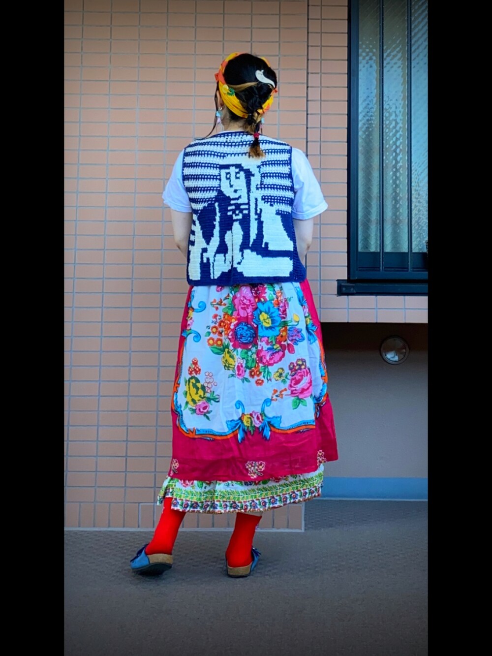 ホワイト系のTシャツ/カットソー、ブルー系のベスト、レッド系のスカートを着用したレディースの夏コーディネートの2枚目の写真