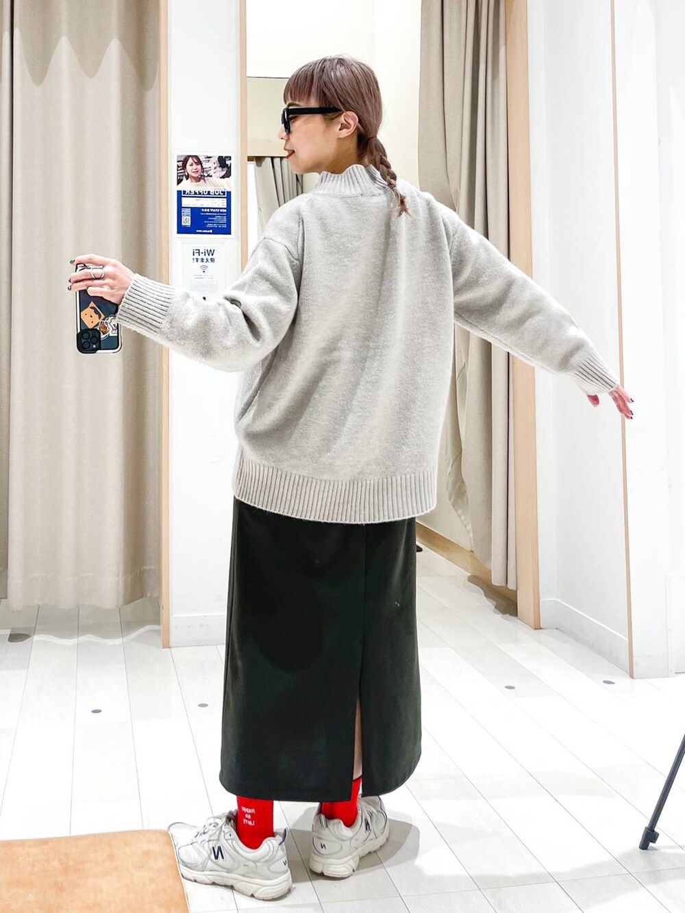 グリーン系のワンピース、ベージュ系のニット/セーター、ブラック系のメガネを着用したレディースの冬コーディネートの3枚目の写真