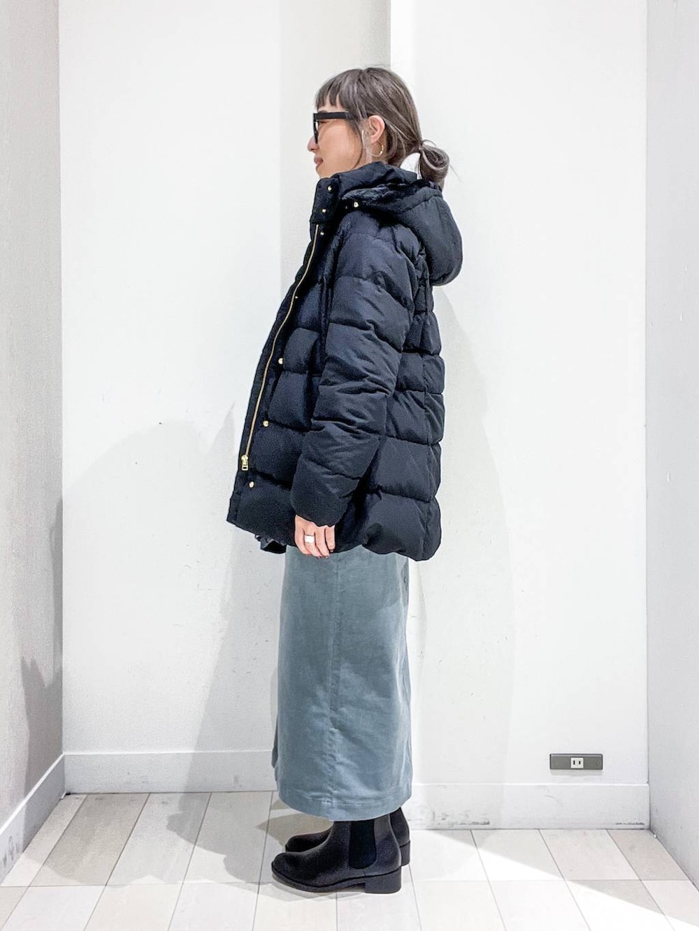 ブラック系のショルダーバッグ、ブラック系のダウンジャケット/コート、グリーン系のスカートを着用したレディースの冬コーディネートの3枚目の写真