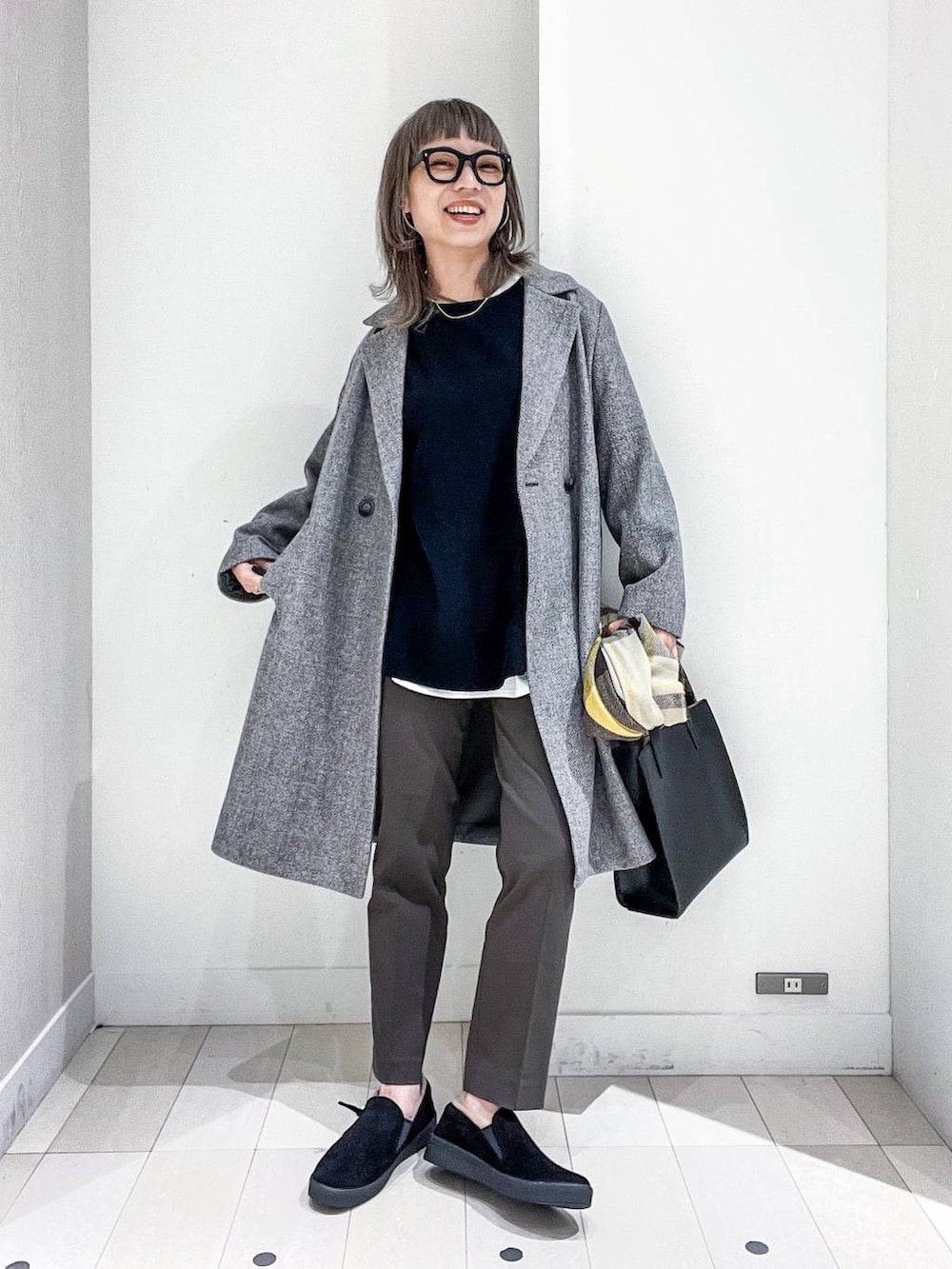 グレー系のチェスターコート、その他のTシャツ/カットソー、ブラック系のニット/セーターを着用したレディースの冬コーディネートの2枚目の写真