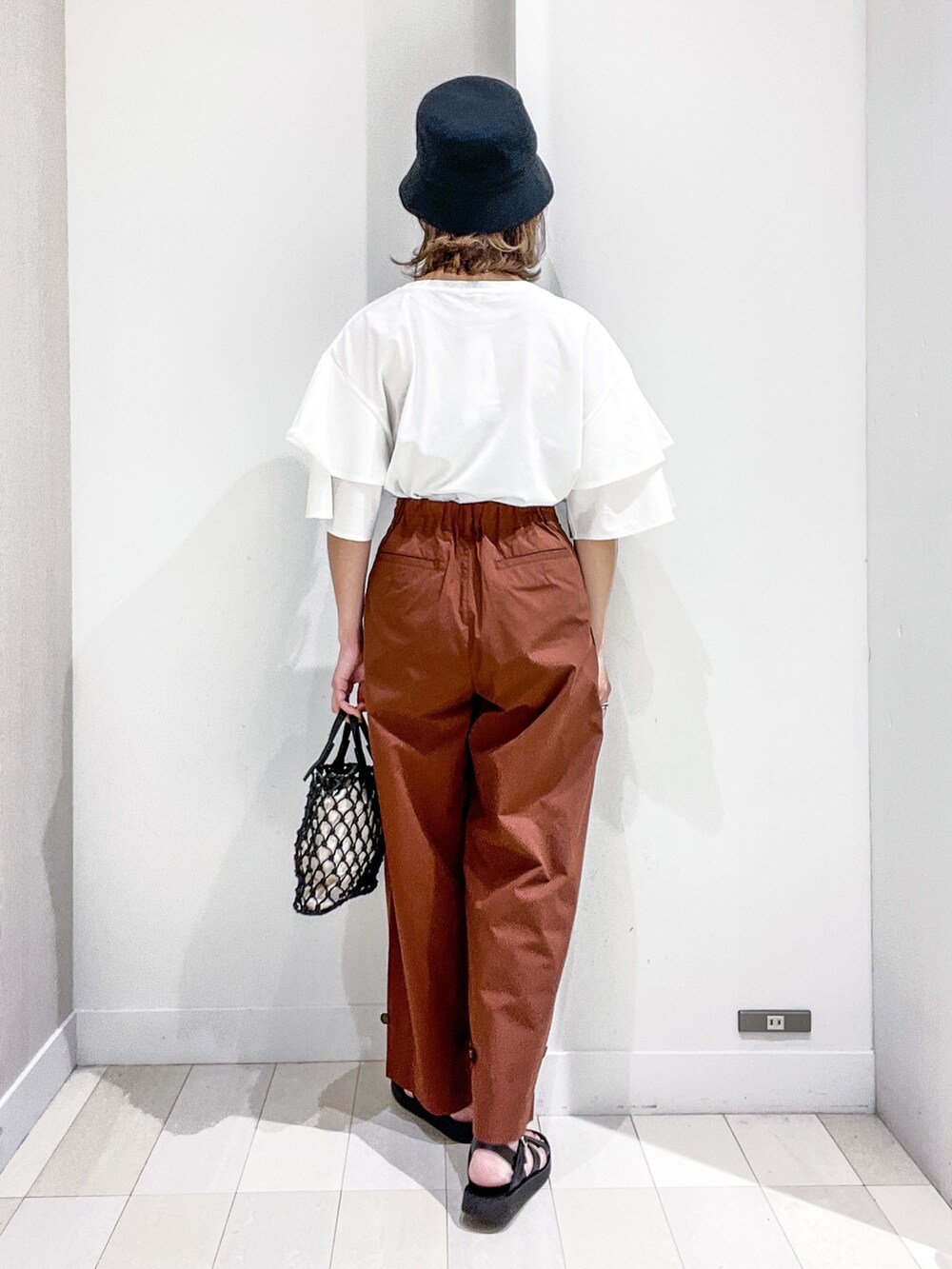 ホワイト系のTシャツ/カットソー、ブラウン系のその他パンツ、ブラック系のバッグを着用したレディースの夏コーディネートの4枚目の写真
