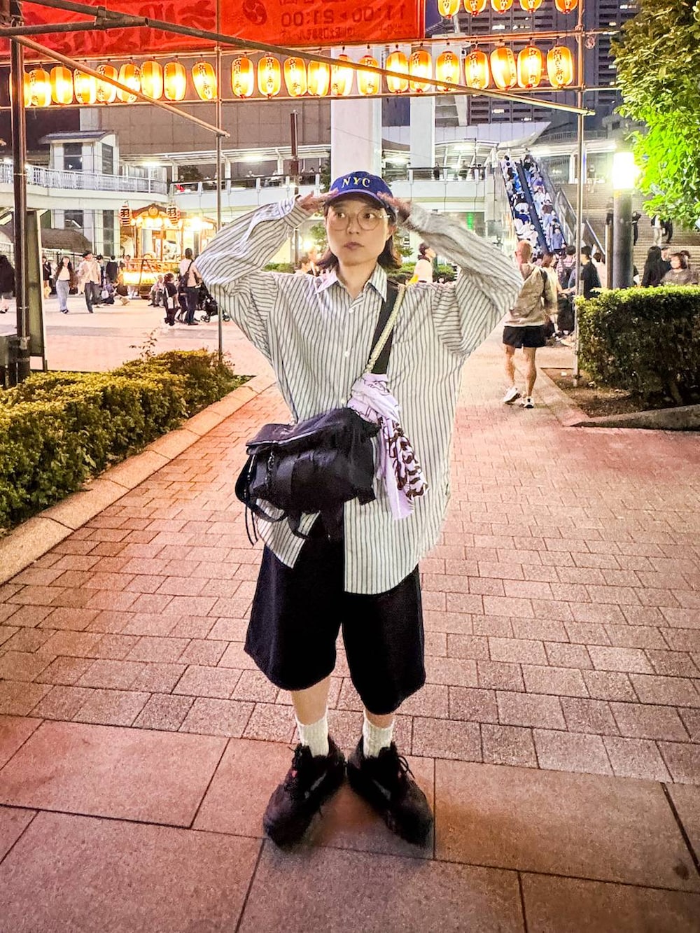 ブラック系のデニムパンツ、ベージュ系のシャツ/ブラウス、ブルー系のキャップを着用したレディースの秋コーディネートの2枚目の写真