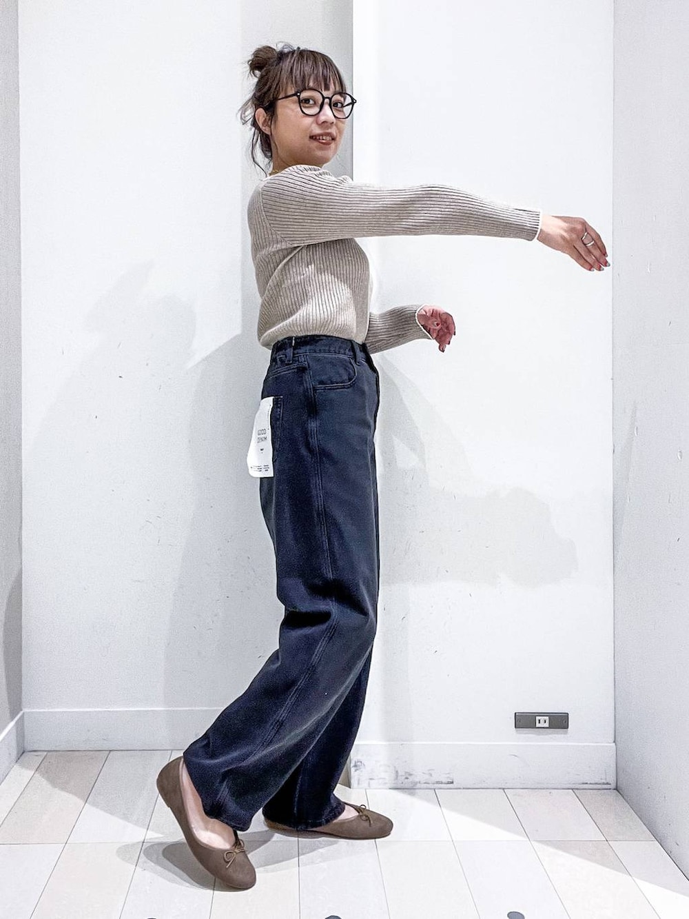 ベージュ系のニット/セーター、ブラック系のデニムパンツ、ベージュ系のトートバッグを着用したレディースの秋コーディネートの9枚目の写真