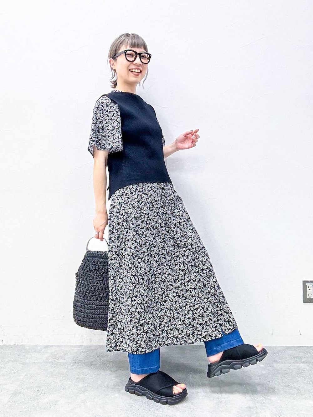 ブルー系のスラックス、ブラック系のサンダル、ブラック系のベストを着用したレディースの春コーディネートの6枚目の写真