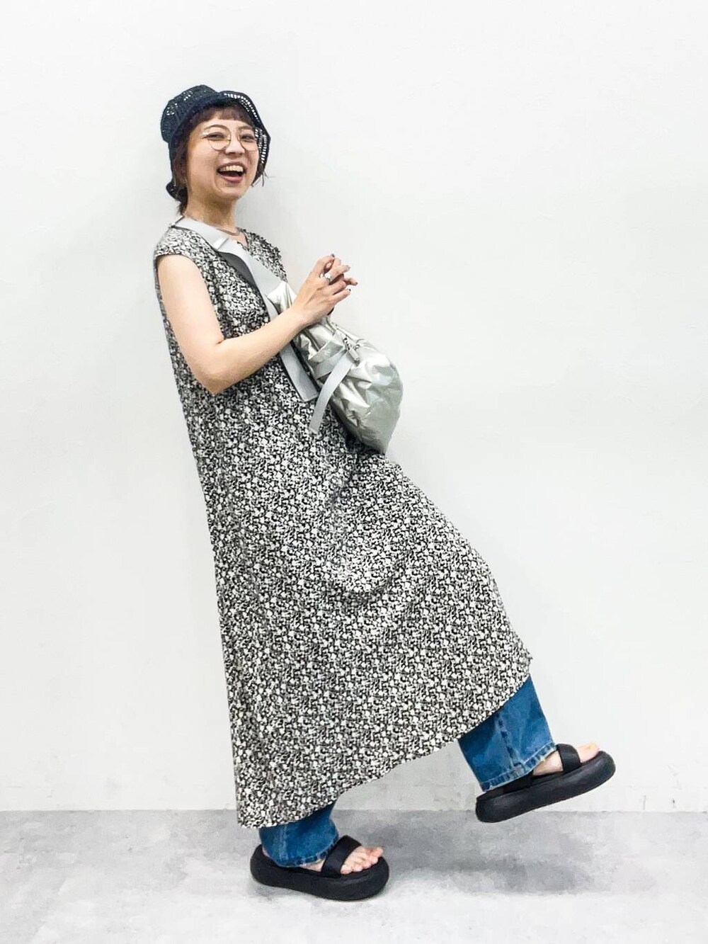 シルバー系のショルダーバッグ、ブルー系のデニムパンツ、ブラック系のサンダルを着用したレディースの夏コーディネートの6枚目の写真