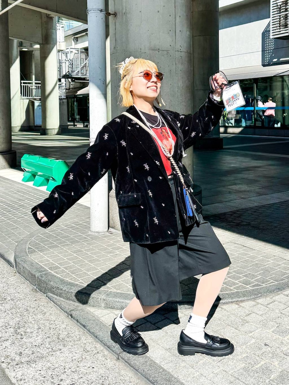 ブラック系のテーラードジャケット、ブラック系のスラックス、ベージュ系のシュシュを着用したレディースの冬コーディネートの3枚目の写真