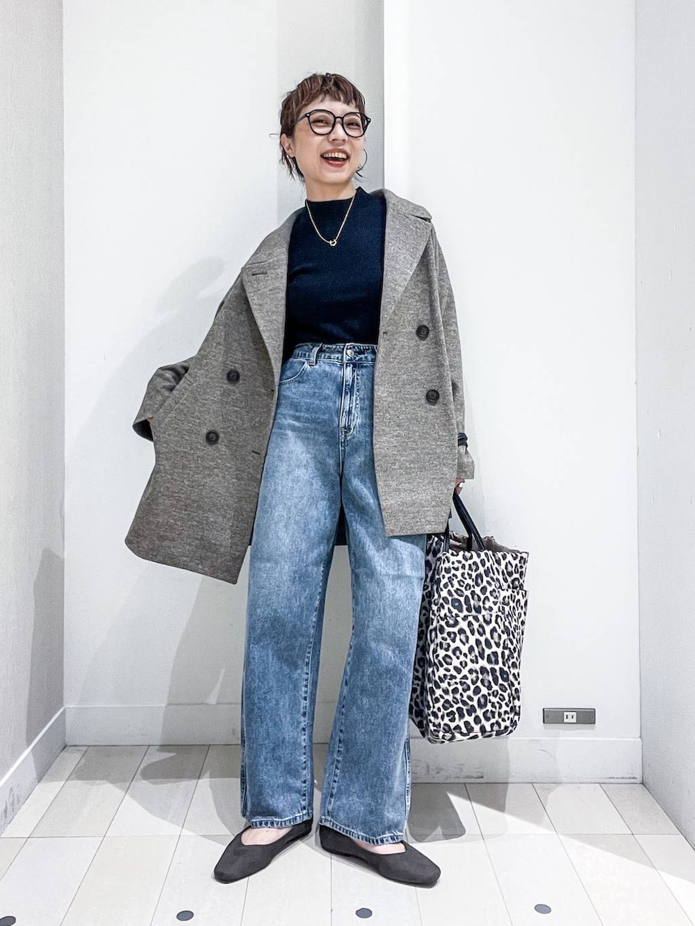 ブラウン系のピーコート、ブラック系のニット/セーター、グレー系のパンプスを着用したレディースの秋コーディネートの2枚目の写真