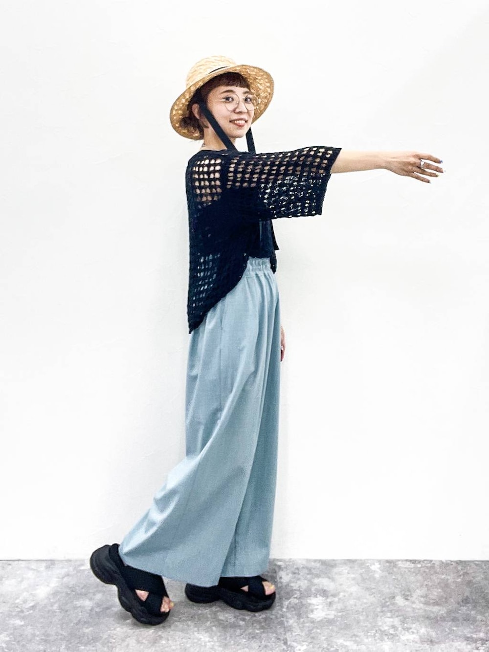 ブラック系のニット/セーター、ブラック系のサンダル、グレー系のタンクトップを着用したレディースの夏コーディネートの5枚目の写真