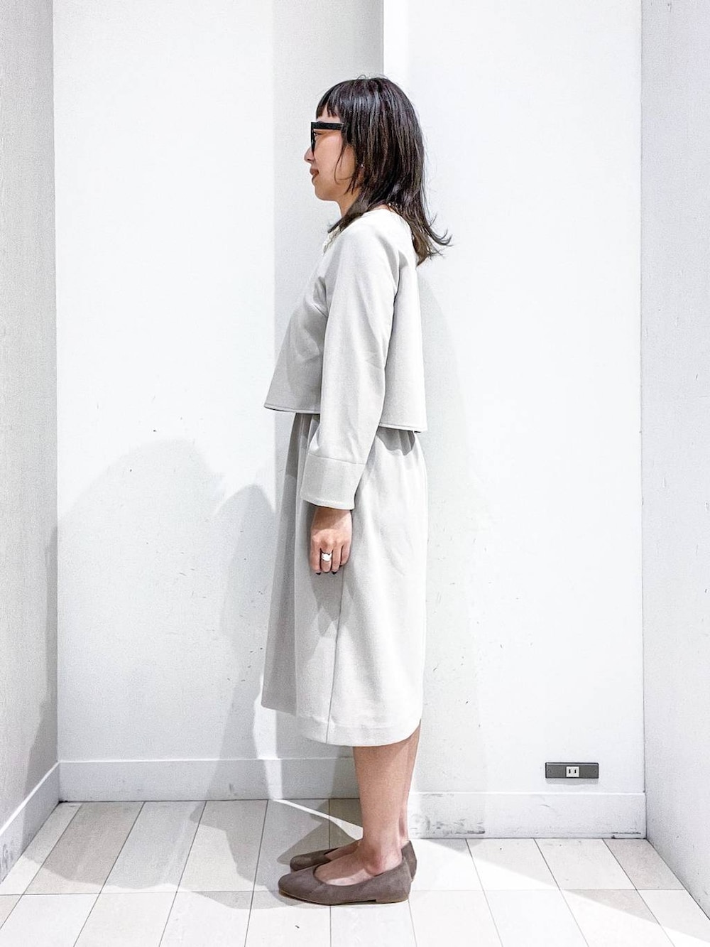ベージュ系のパンプス、ホワイト系のノーカラージャケット、ベージュ系のワンピースを着用したレディースの冬コーディネートの7枚目の写真