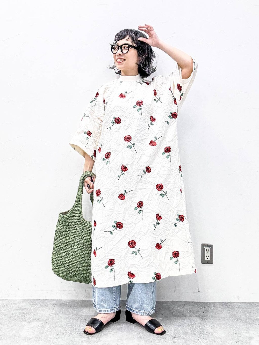 グリーン系のショルダーバッグ、ブラック系のサンダル、ブルー系のデニムパンツを着用したレディースの春コーディネートの7枚目の写真