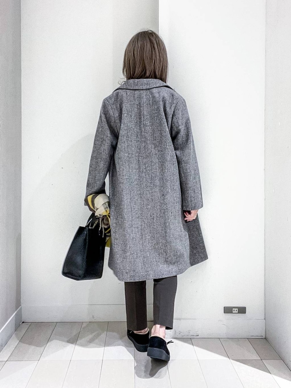 グレー系のチェスターコート、その他のTシャツ/カットソー、ブラック系のニット/セーターを着用したレディースの冬コーディネートの4枚目の写真