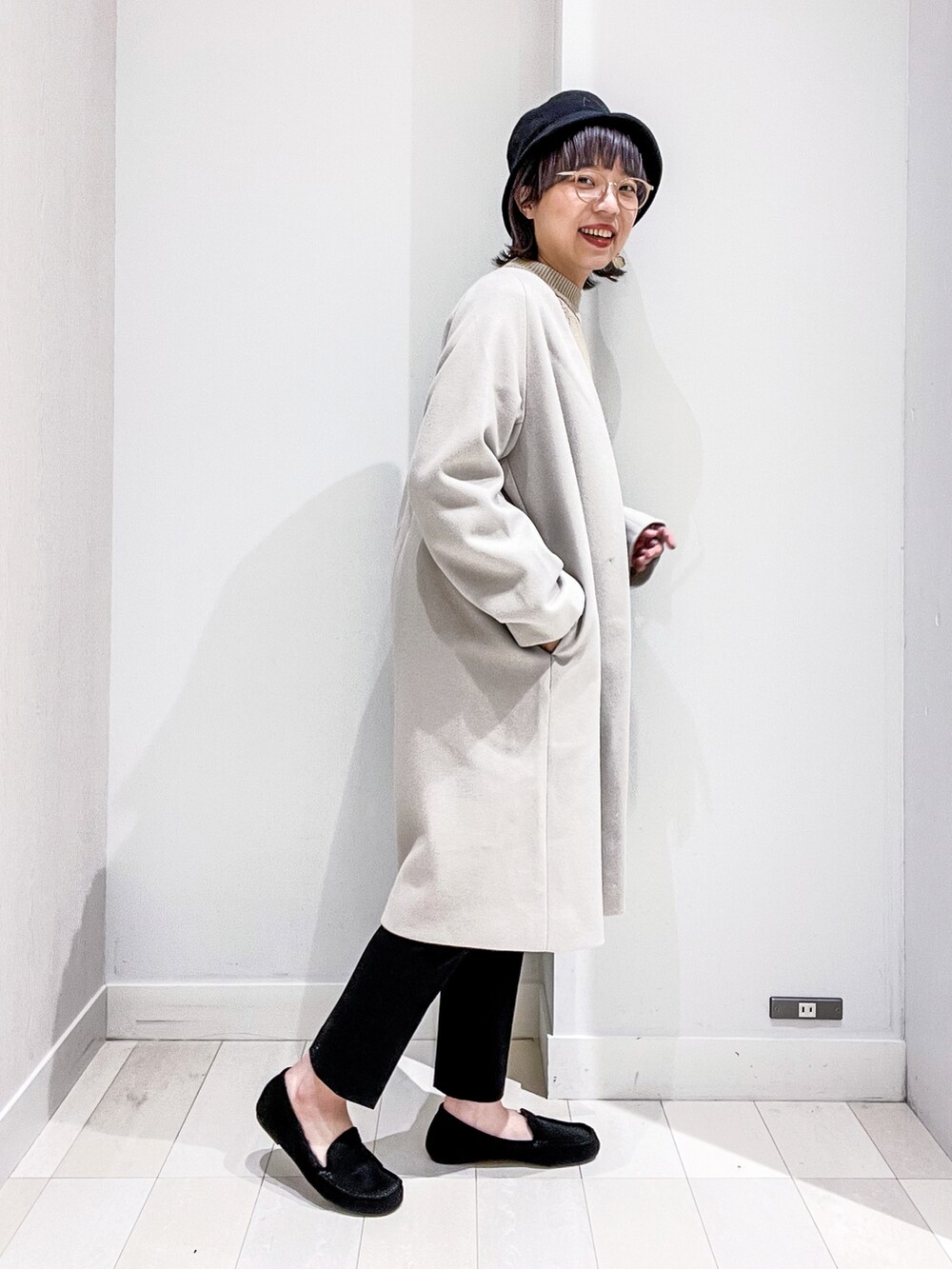 ベージュ系のニット/セーター、グレー系のノーカラーコート、ブラック系のその他パンツを着用したレディースの冬コーディネートの2枚目の写真