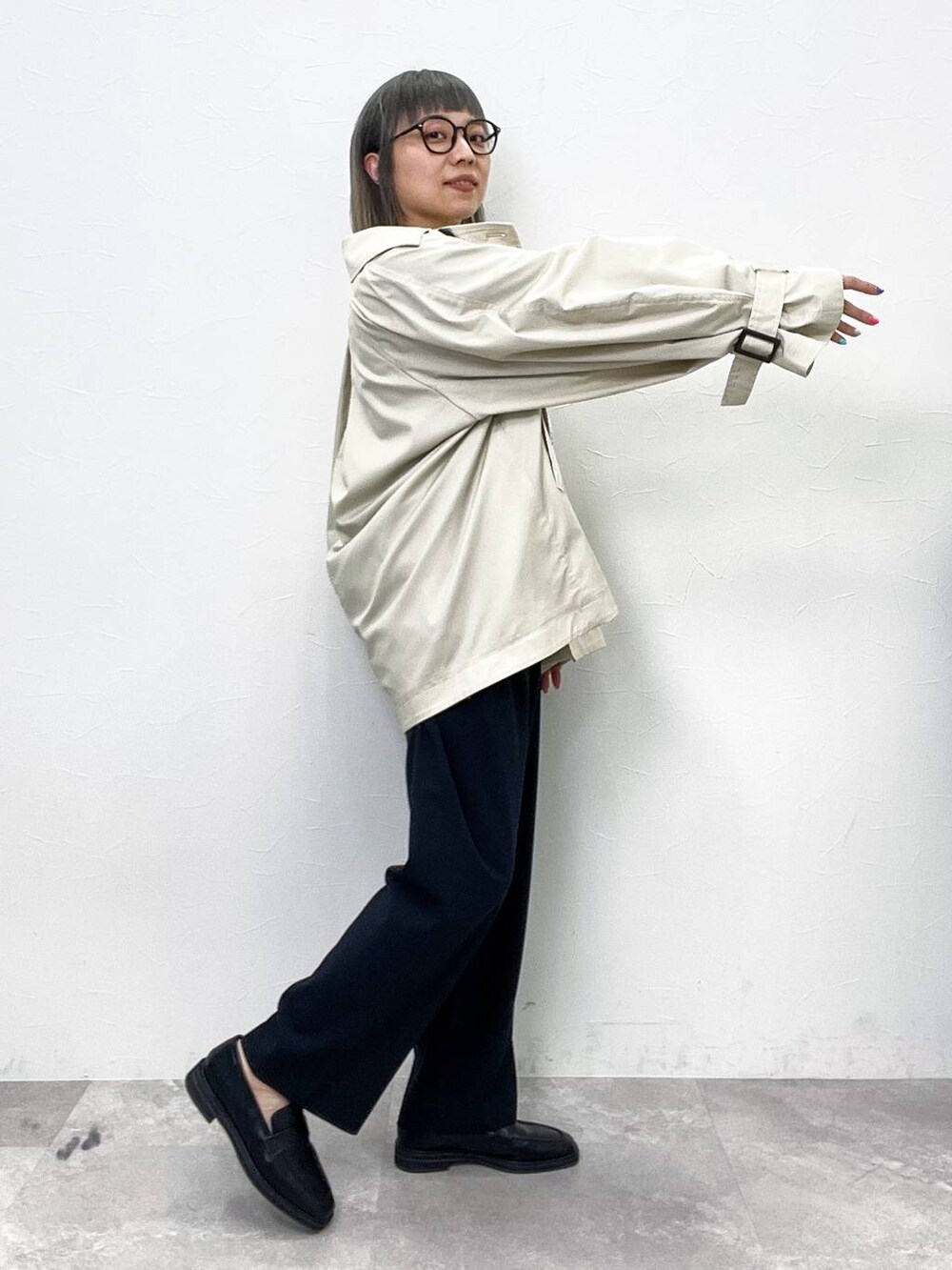 ブラック系のローファー、ベージュ系のトレンチコート、ブラック系のその他パンツを着用したレディースの春コーディネートの5枚目の写真