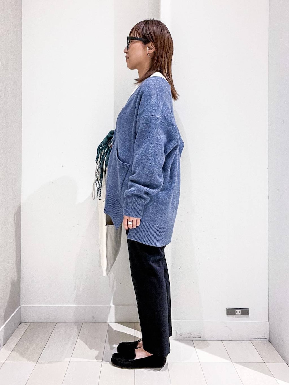 ホワイト系のトートバッグ、グレー系のTシャツ/カットソー、ブルー系のカーディガン/ボレロを着用したレディースの秋コーディネートの3枚目の写真