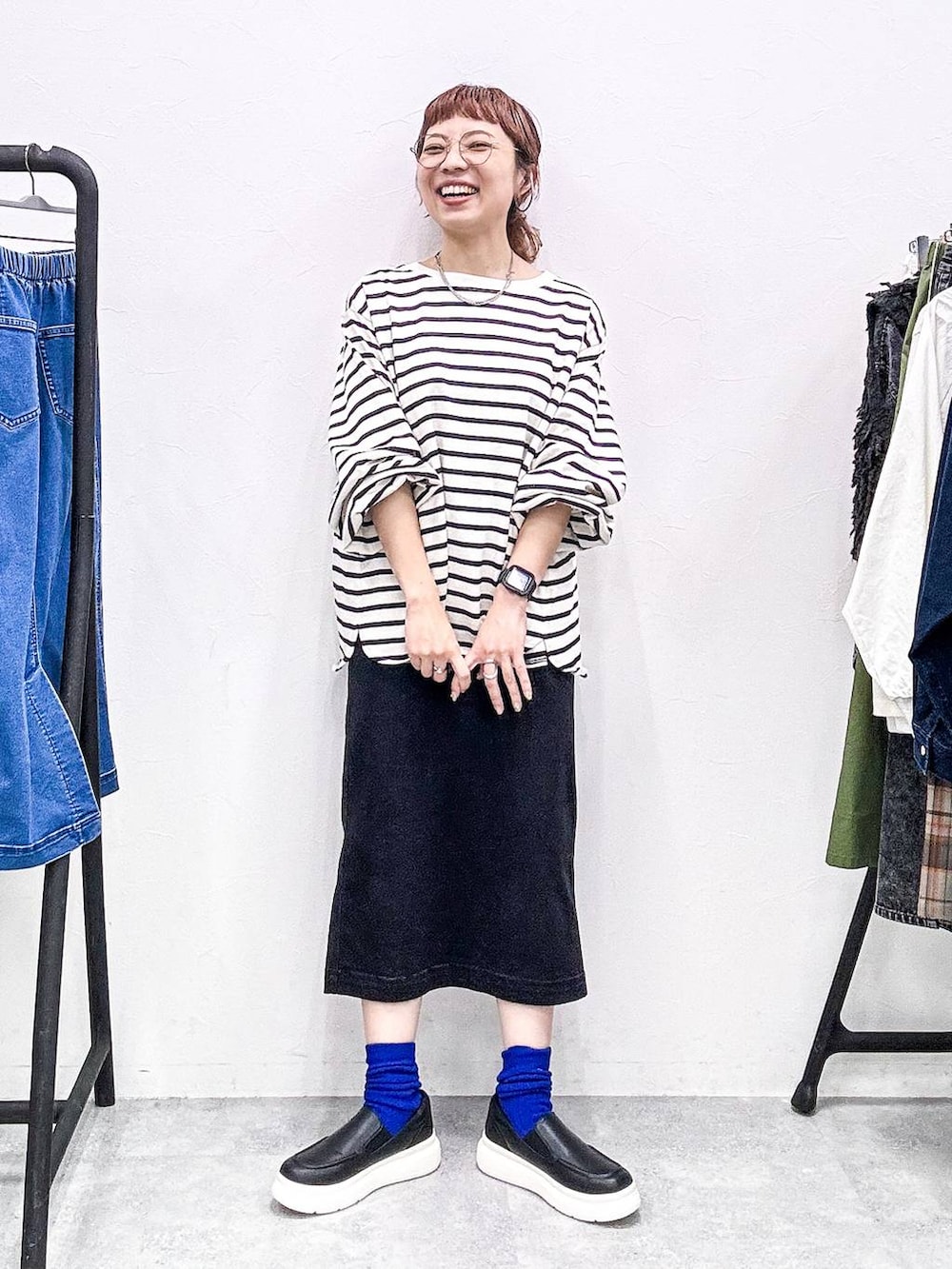 ブラック系のスカート、ブラック系のスリッポン、グレー系のTシャツ/カットソーを着用したレディースの秋コーディネートの2枚目の写真