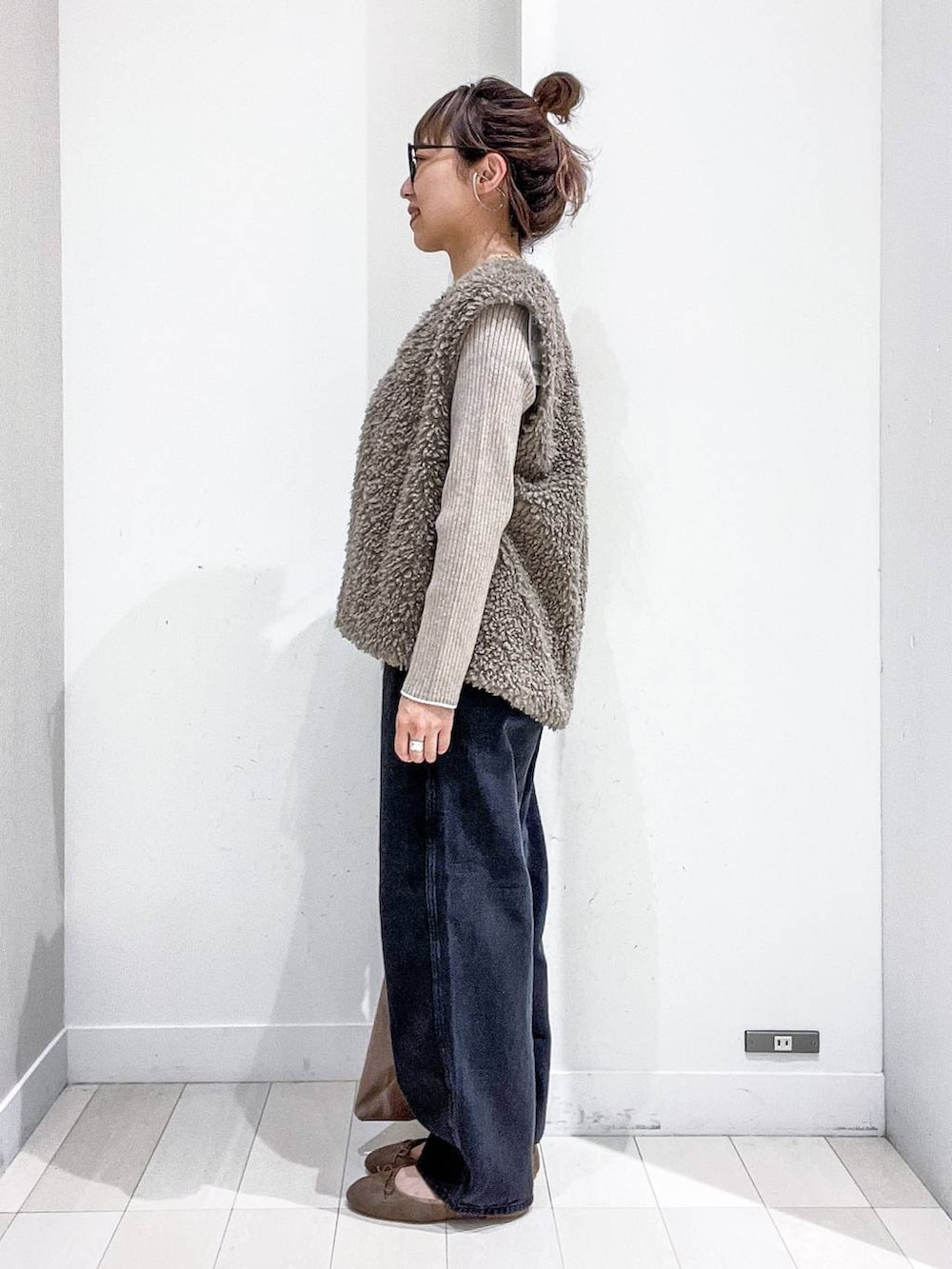 ベージュ系のニット/セーター、ブラック系のデニムパンツ、ベージュ系のトートバッグを着用したレディースの秋コーディネートの3枚目の写真