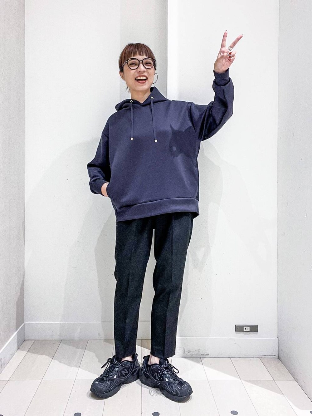 ブラック系のバックパック/リュック、グレー系のノーカラーコート、ブラック系のその他パンツを着用したレディースの秋コーディネートの6枚目の写真