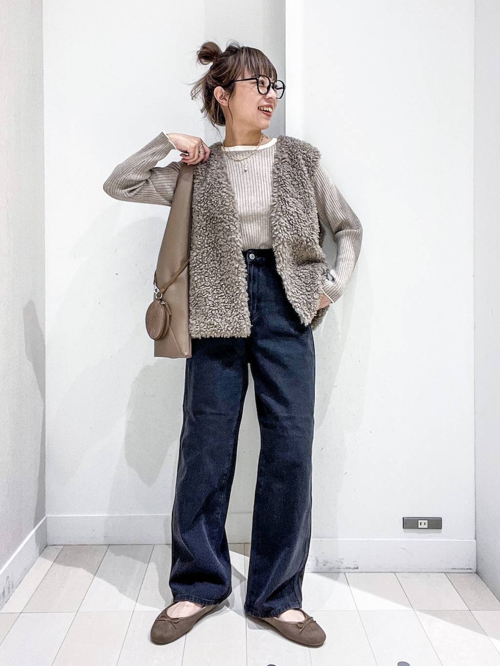 ベージュ系のニット/セーター、ブラック系のデニムパンツ、ベージュ系のトートバッグを着用したレディースの秋コーディネートの2枚目の写真