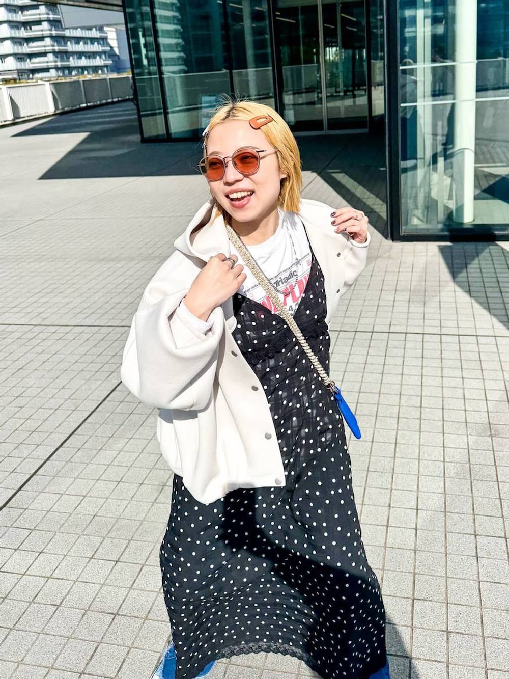 ホワイト系のブルゾン、ブラック系のワンピースを着用したレディースの冬コーディネートの4枚目の写真