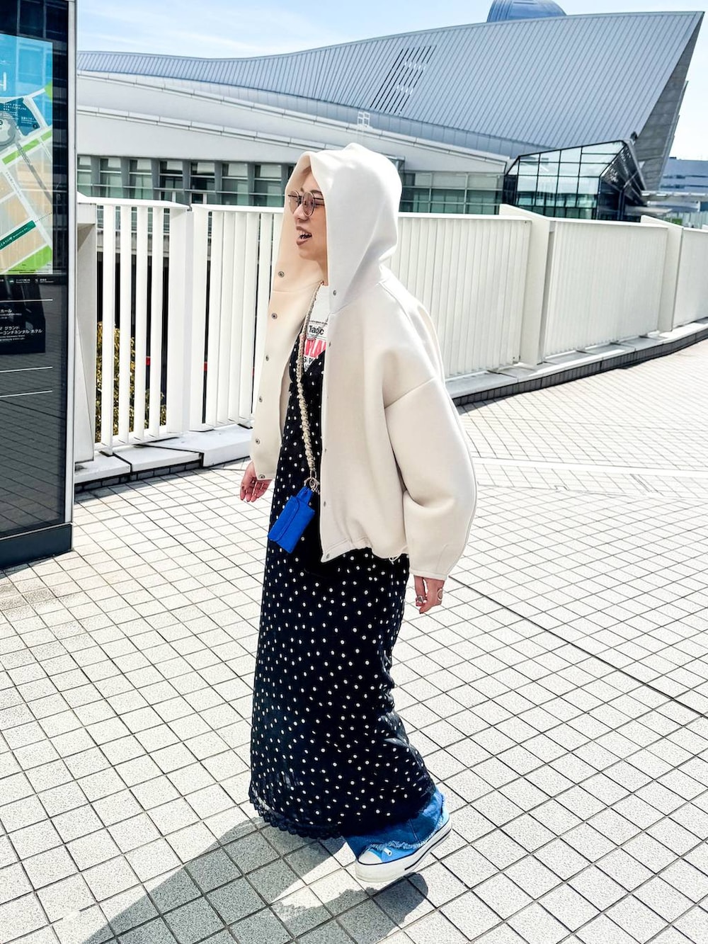 ホワイト系のブルゾン、ブラック系のワンピースを着用したレディースの冬コーディネートの2枚目の写真