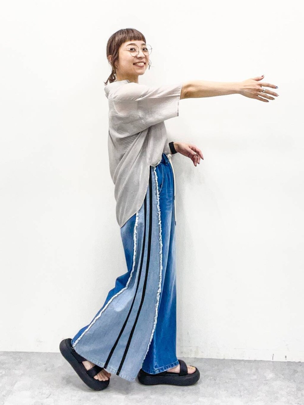 グレー系のシャツ/ブラウス、グレー系のタンクトップ、ブルー系のデニムパンツを着用したレディースの夏コーディネートの5枚目の写真