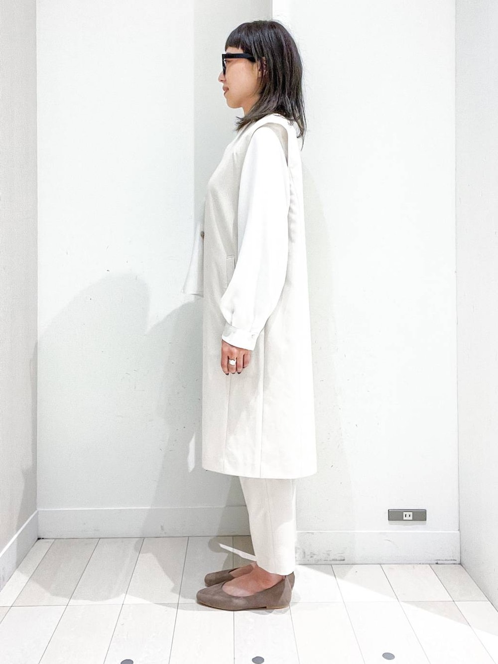 ベージュ系のパンプス、ホワイト系のベスト、ホワイト系のシャツ/ブラウスを着用したレディースの冬コーディネートの3枚目の写真